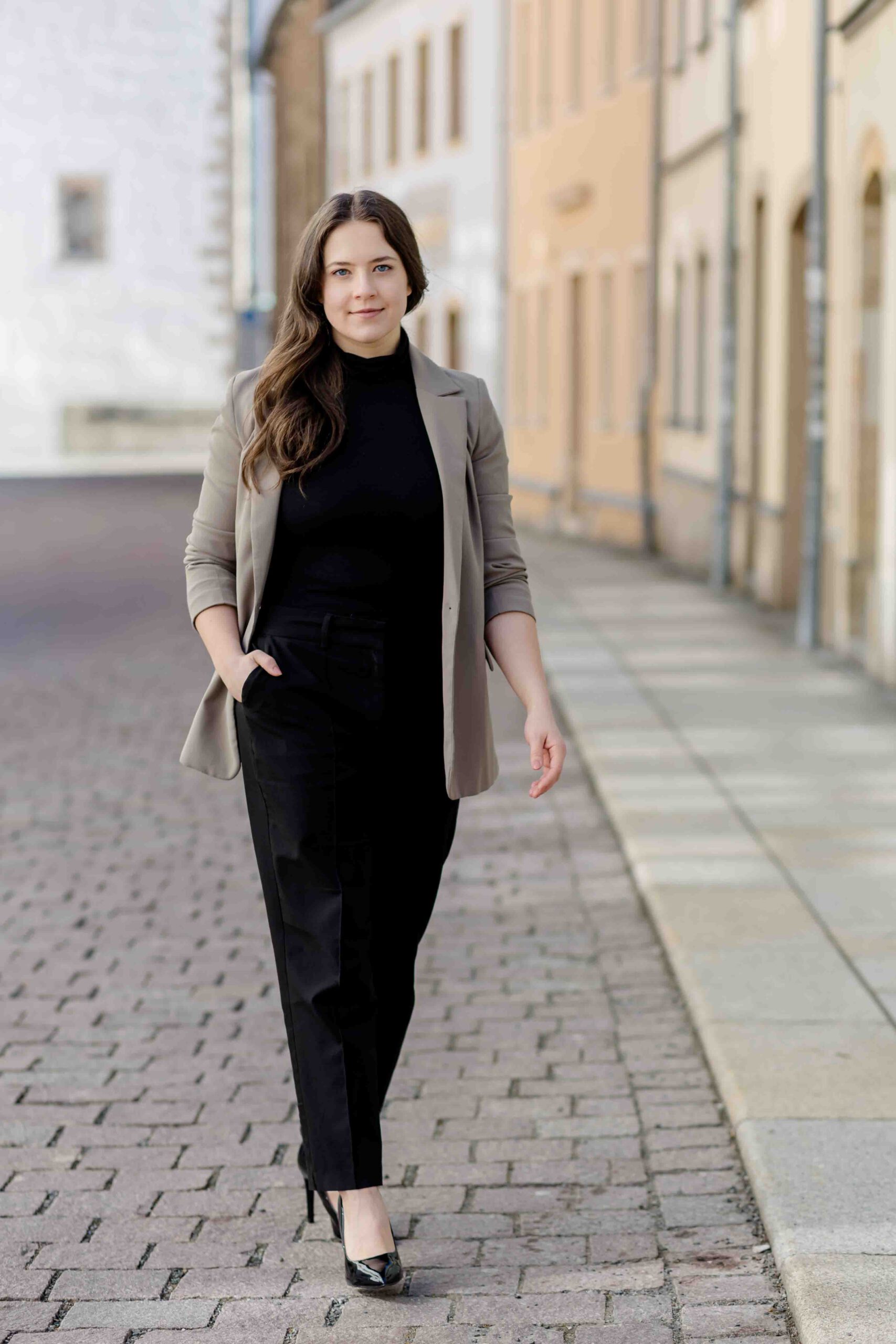 Authentisches Bewerbungsfoto einer jungen Frau mit leichtem Lächeln, schwarzem Oberteil und neutralem Hintergrund – professionell und natürlich aufgenommen - Bewerbungsfotos Freiberg - Bewerbungsbilder