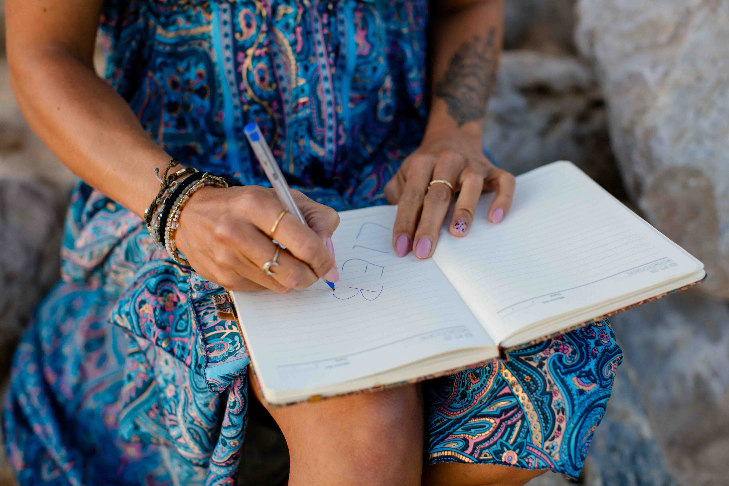 Frau im blauen Kleid läuft durch den Sand
