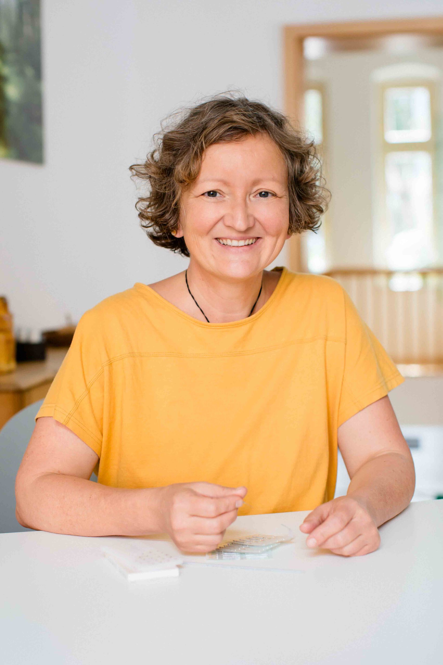 Frau Kinesiologin lächelt in die Kamera - Businessfotoshooting