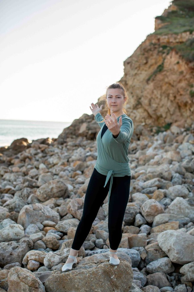 Frau macht Qigong am Steinstrand - Qigong Fotogshooting - Personal Branding Fotos für Coaches