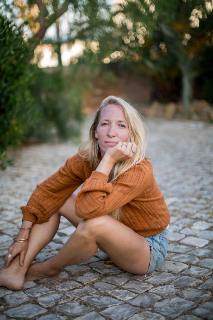 blonde Frau mit langen Haaren schaut in die Kamera